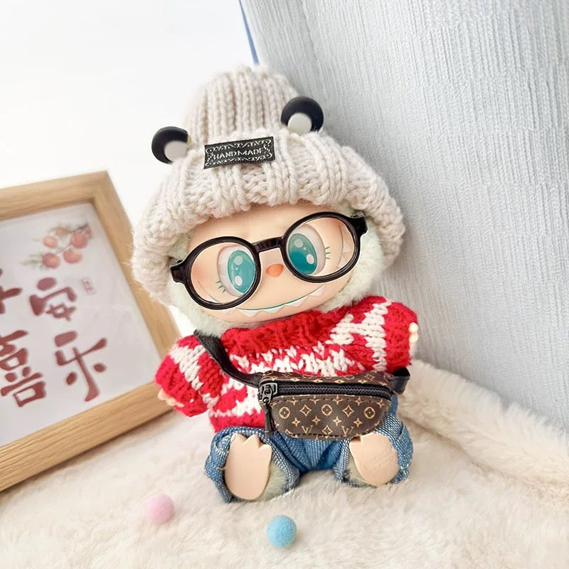 Toy figure wearing a white knit hat, red sweater, denim shorts, and glasses on a white background.